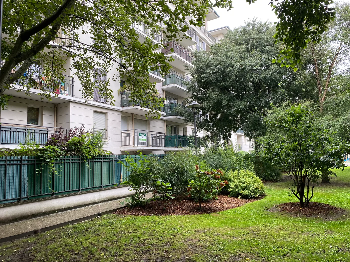 Jardin arboré au pied d’un immeuble avec balcons — Rueil Malmaison, 92.
