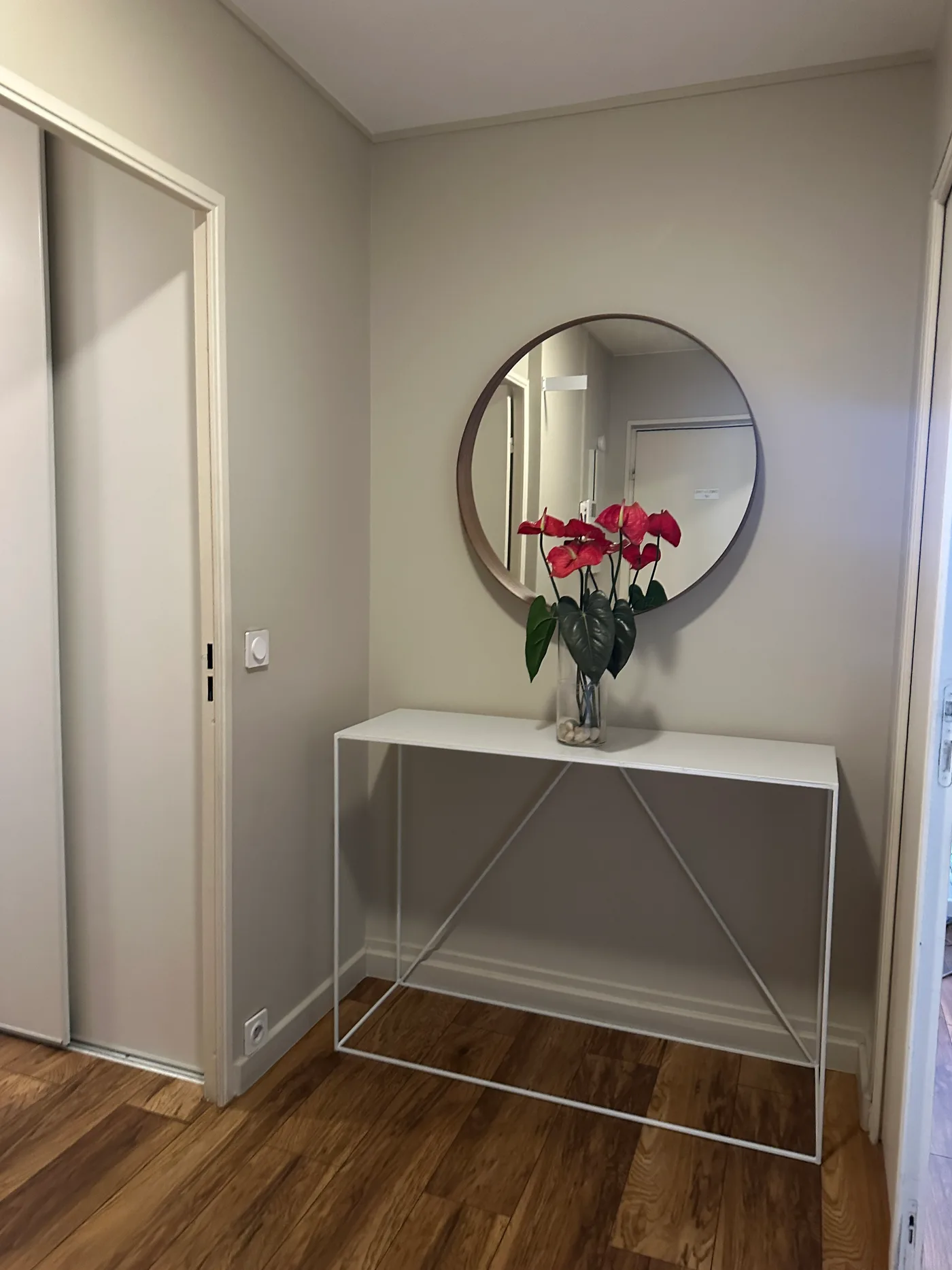 Entrée avec console, miroir rond et parquet — Villiers sur Marne, 94.