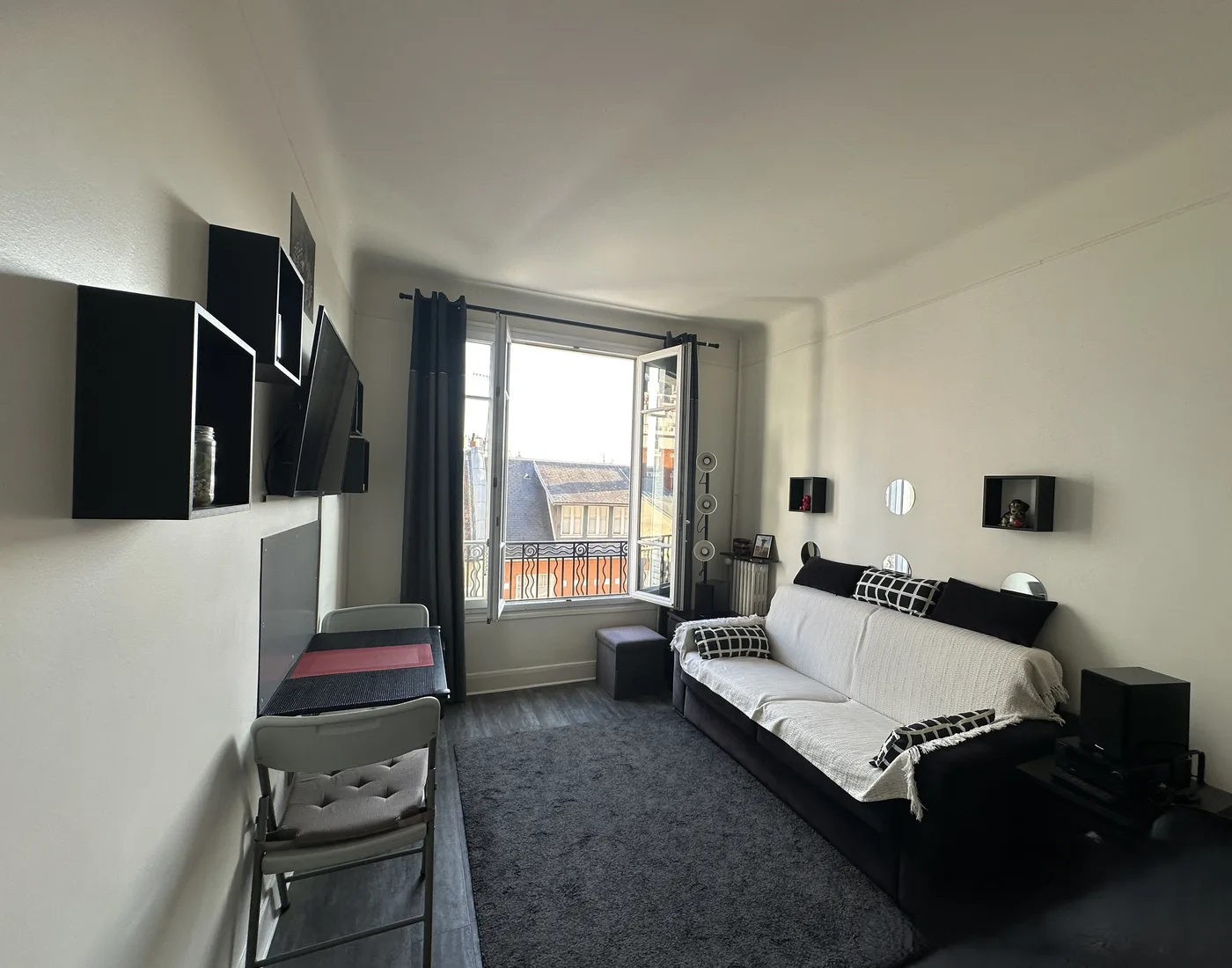 Pièce de vie avec canapé convertible et porte-fenêtre sur le balcon — Boulogne Billancourt, 92.